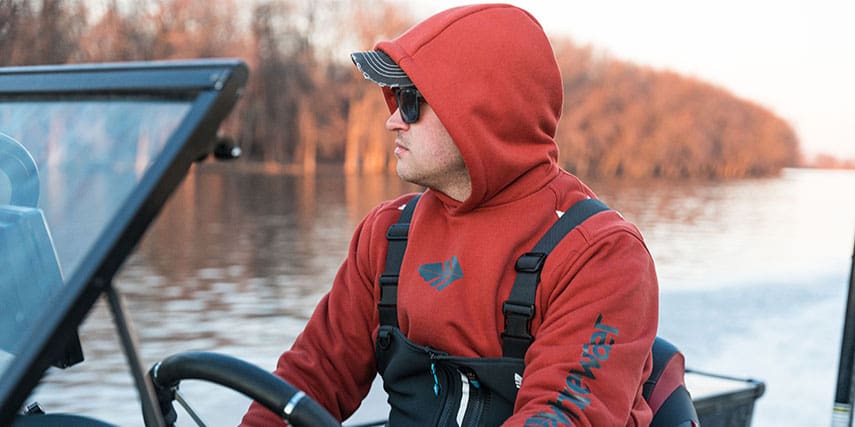 Fisherman driving boat wearing hoodie